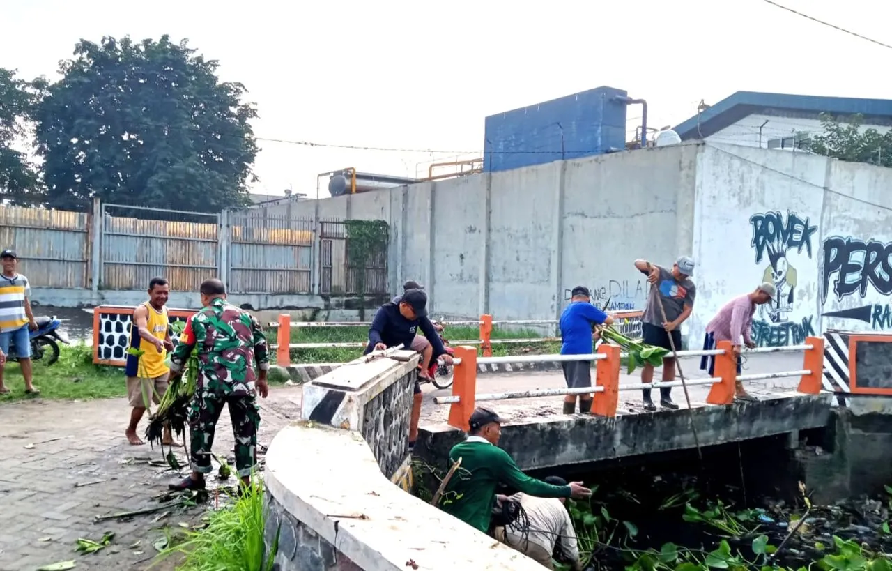 Babinsa Koramil 0817/01 Driyorejo Bersama Warga Kerja Bakti Bersihkan Sungai Sumput
